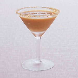 A rum and maple pumpkin cocktail in a martini glass with sugar on the rim.