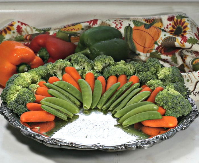 carrots, peas and broccoli on a siler tray carrots and peas layered on broccoli florets