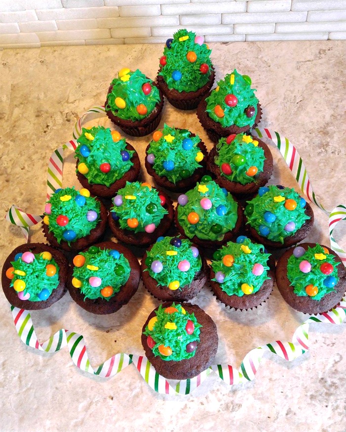 Arrange the Christmas tree cupcakes in the shape of a tree