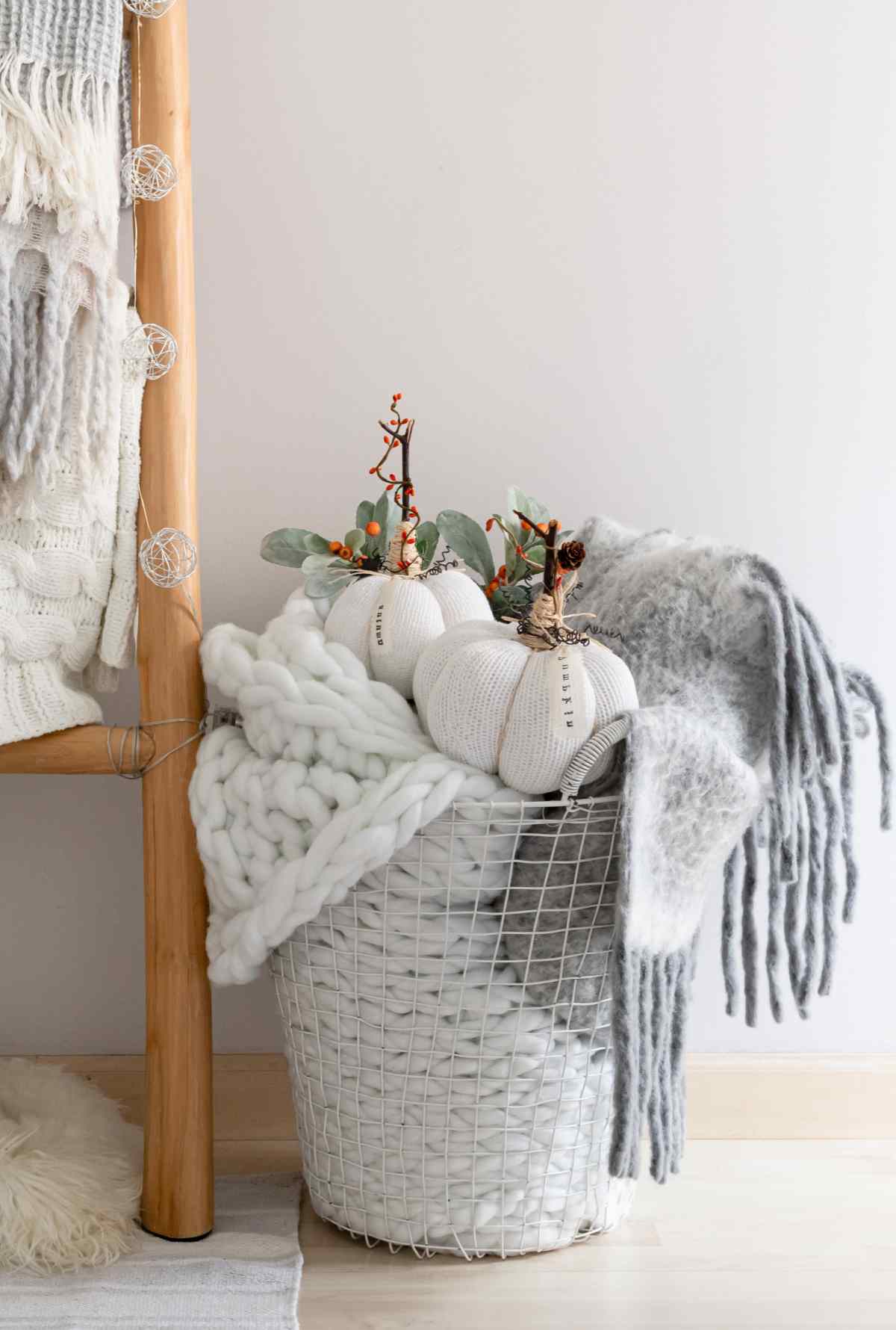 Fabric pumpkins in a basket with blankets.