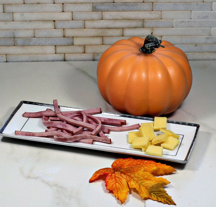 Ham and cheese on a plate. ham and cheese on a plate with leaves and pumpkin.