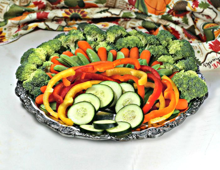platter of broccoli, carrots, peas, peppers and cucumbers peppers and cucumbers on a silver platter