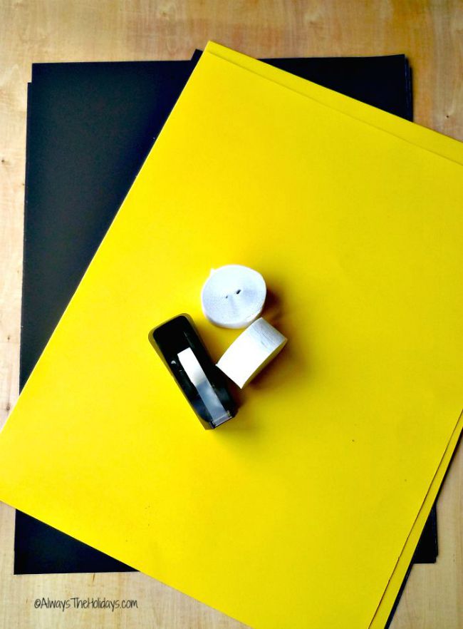 Black and yellow poster board, paper streamers and tape.