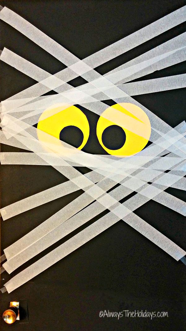 Eyeballs and paper streamers on black board.