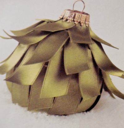 Cracked ornament covered with a olive green strips of fabric to resemble a skirt.