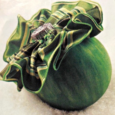 A green painted ornament with a ruffled top.
