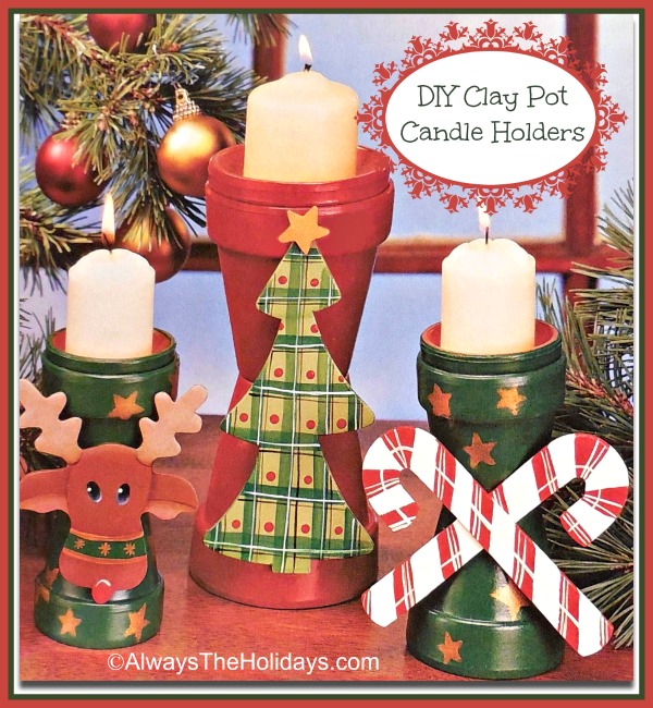 Three DIY Clay Pot Candle Holders with candles in them on a table surrounded by Christmas tree branches.