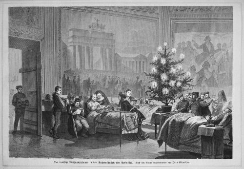 A black and white photo showing early use of Christmas trees, with many people gathered around a lit Christmas tree.