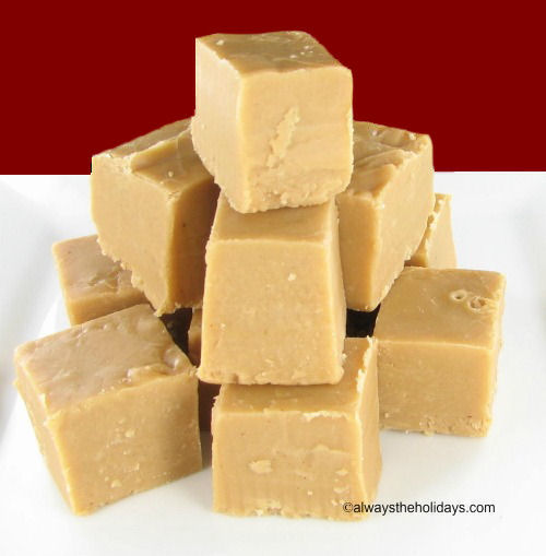 A pile of Baileys Irish cream fudge on a plate. A pile of Bailey's Irish cream fudge on a white plate against a red background.