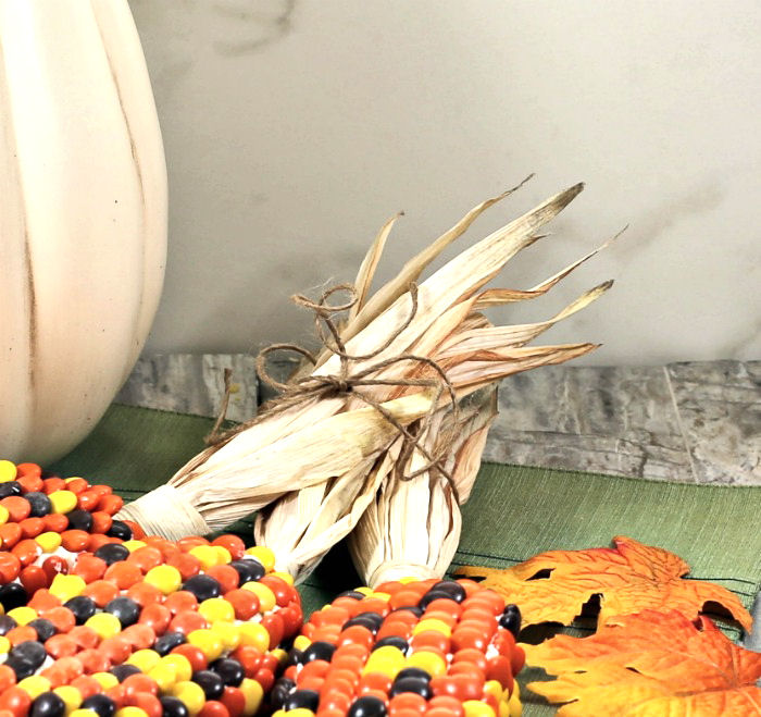 corn husks attached to ears of edible Indian corn. Corn husks on the end of Indian corn cakes.