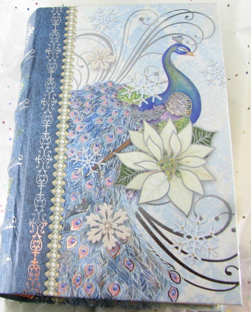 A book container for fudge with a peacock and white flower on the cover.