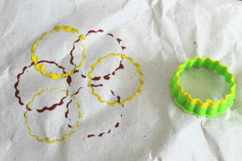 Cookie cutter gift wrap idea with red and yellow paint.