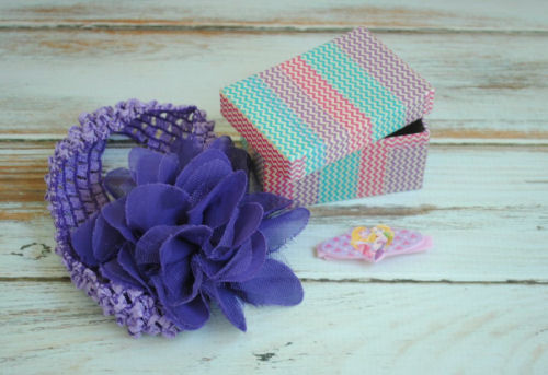 Chevron trinket box next to a purple headband wit ha purple fabric flower on it.