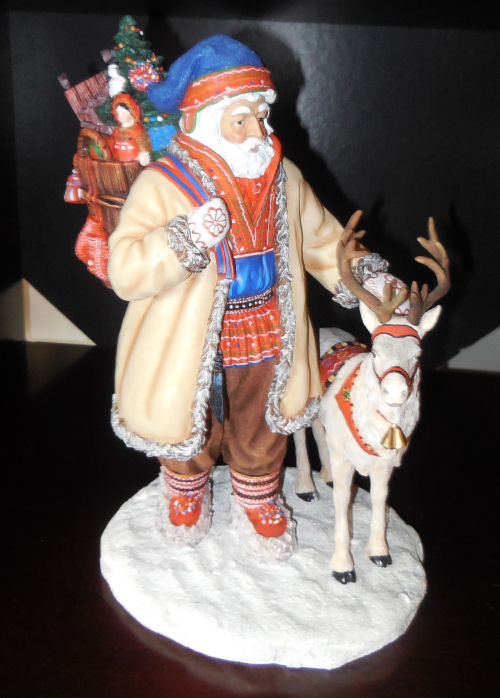 Santa Claus Nordic style next to a reindeer holding a bag of presents.