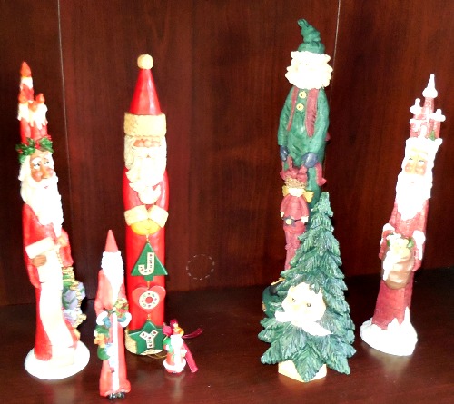 Four tall pencil Santas, one short pencil Santa, one Santa shaped like a Christmas tree, and one tiny Santa.