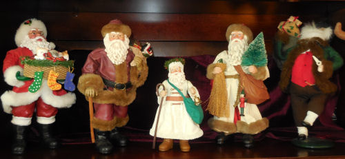 Five different softique Santas arranged in a line.