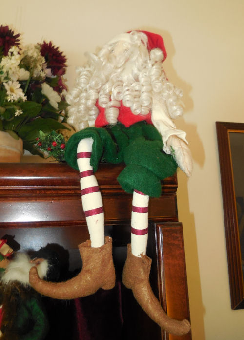 Santa Claus elf on a shelf. Sitting Santa Claus elf on a shelf.