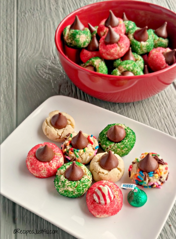 Christmas kiss cookies. A plate and bowl of festive holiday kiss cookies with different color sprinkles on the cookies, and different Hershey's kiss candies inside them.