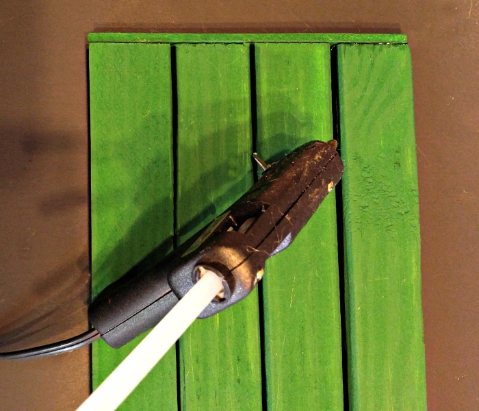 Glue the small piece of plywood to the bottom of the sign to hold the slats in place