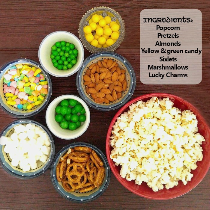 Bowls of snack foods with overlay reading Ingredients: popcorn, pretzels, almonds, yellow and green candy sixlets, marshmallows, Lucky Charms.