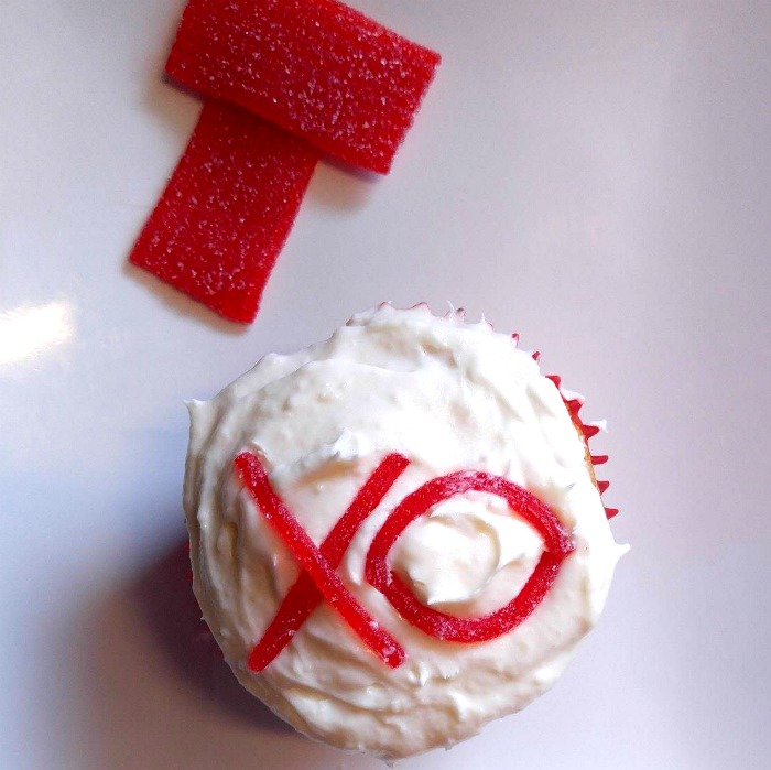 Decorating cupcakes with an XO on a Valentine Cupcake
