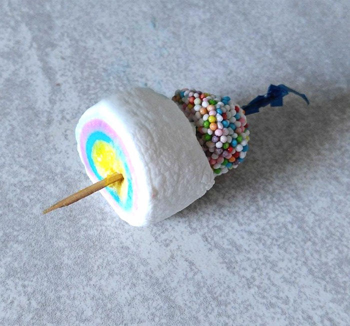 A marshmallow and licorice allsort on a cocktail pick. A marshmallow allsort garnish for an Easter Cocktail.
