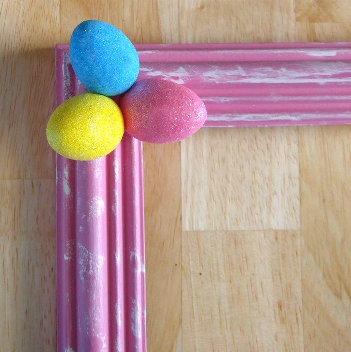Foam Easter eggs on the corner of a picture frame Add the Easter eggs to the picture frame