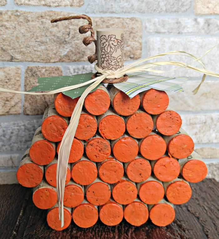 A wine cork pumpkin craft made from 34 recycled corks and paper leaves.