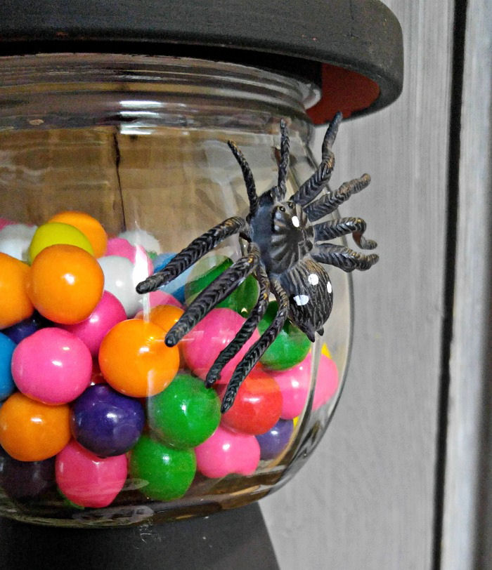 Add a plastic spider to the bubble gum jar. Black plastic spider glued to the front of a DIY Halloween gumball machine.