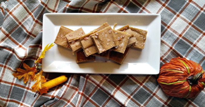 Salted pumpkin fudge Eleven vegan salted pumpkin fudge squares on a white plate on a checkered tablecloth with fake fall leaves and pumpkin beside it.