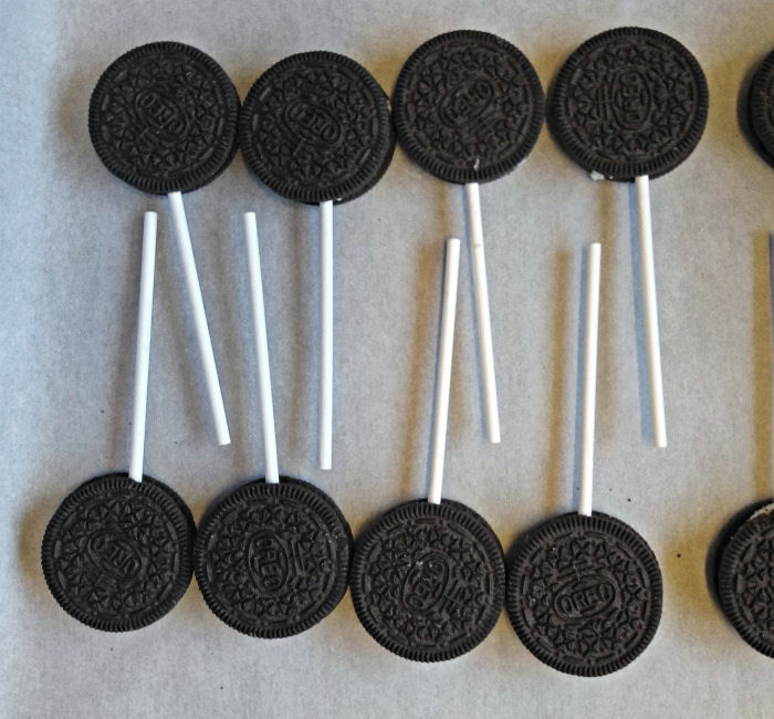 Oreo cookie pops on parchment paper Oreo cookies with stick handles