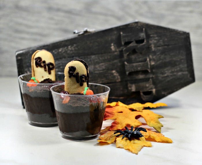 Dirt cups with RIP cookies, leaves and a wood coffin.