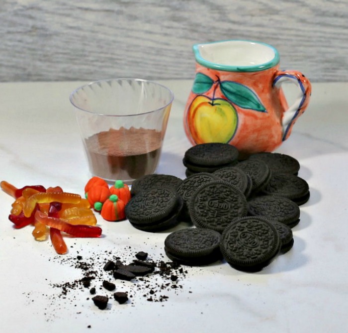ingredients for dirt cups milk, pudding mix, Oreo cookies and gummy worms.