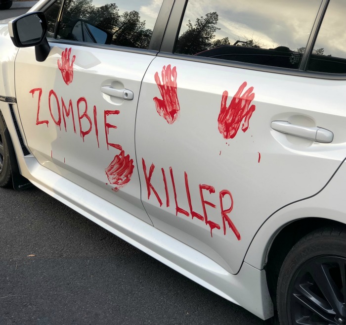 Zombie killer car. Halloween car decorations: Zombie killer and bloody hand prints on a car.