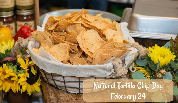 bowl of tortilla chips and some flowers on a counter February 24 is National Tortilla Chip Day