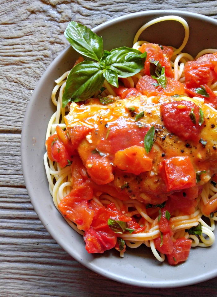 garlic chicken over spaghetti Buttery garlic chicken in a tomato sauce over spaghetti