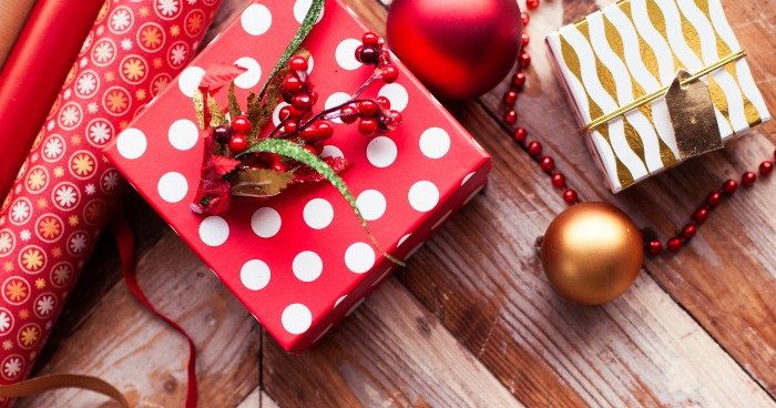 Creative Christmas gift wrap Rolls of Christmas wrap, ornament and small present in red and white paper.