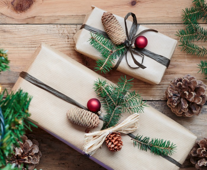 Rustic Christmas gift wrapping. Christmas presents wrapped with fir boughs, pine cones and berry