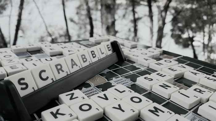 A Scrabble board and Scrabble tiles. A black and white photo of a Scrabble board with tiles that spell out "Scrabble" to celebrate National Scrabble Day.