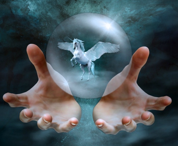 A flying unicorn in a sphere. Two hands holding a clear glass ball with a flying unicorn inside.