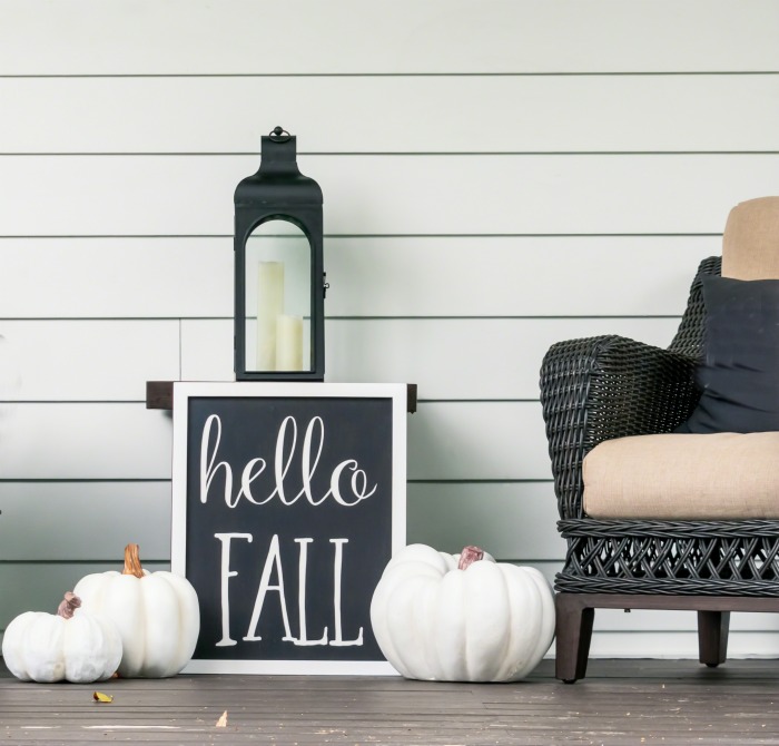 Halloween porch decor. Halloween porch decor with white pumpkins, chair, lantern and a sign that says "hello fall."