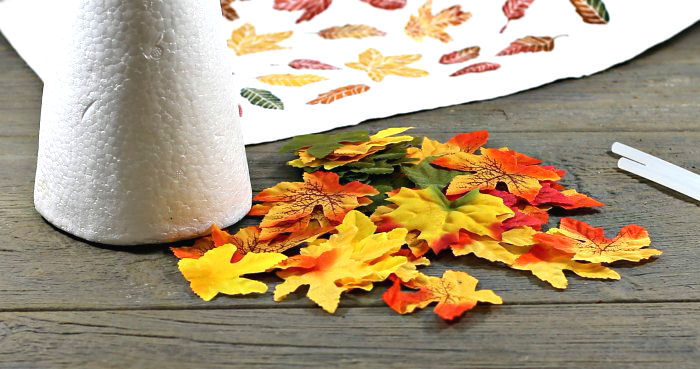 foam cone and silk leaves Variety of silk leaves with a foam cone and glue sticks.