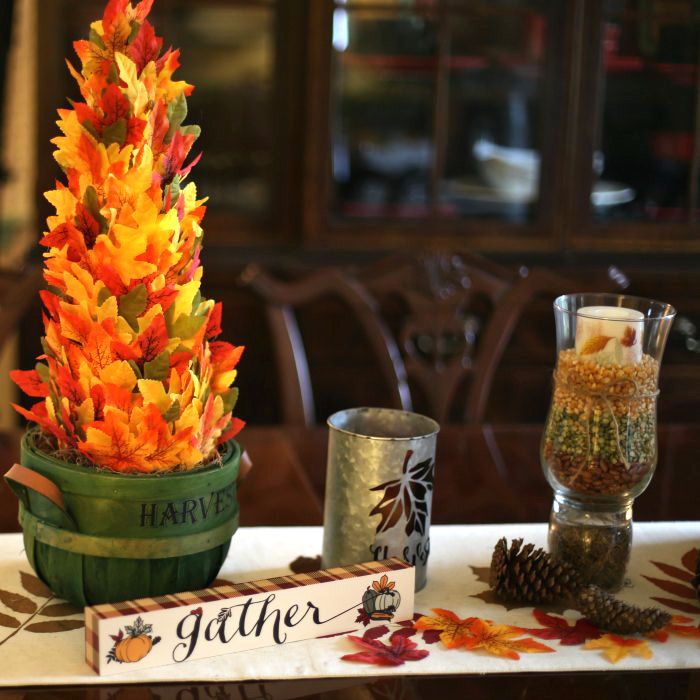 Thanksgiving DIY tree centerpiece with leaf tree in basket, gather sign and candles.