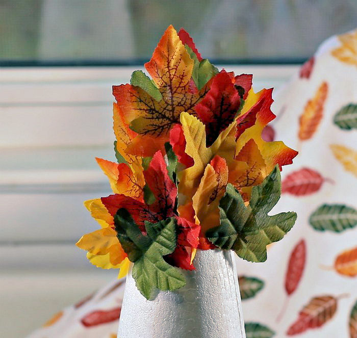 fall leaves on a foam cone Top of the foam tree - adding more leaves