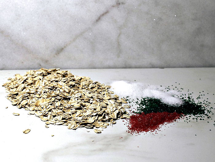 Ingredients for magic reindeer food. Rolled oats, granulated sugar, and sugar crystals on a countertop.