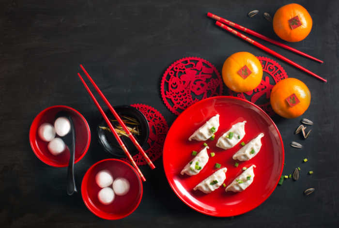 Chinese New Year food. Food on red plates with chopsticks for Chinese New Year.