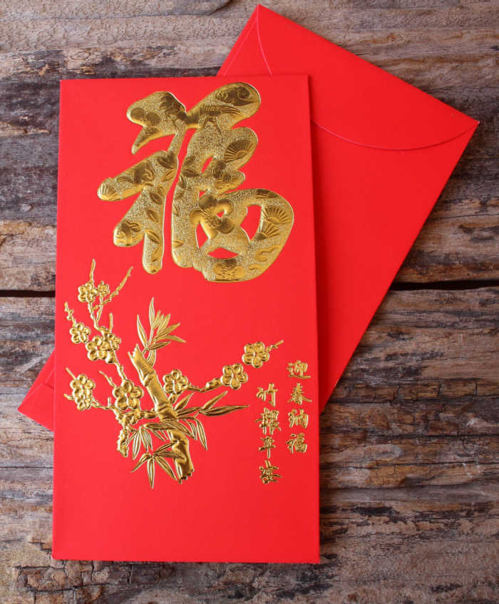 Chinese new year red money envelope Gold and red money envelope on a wood board.