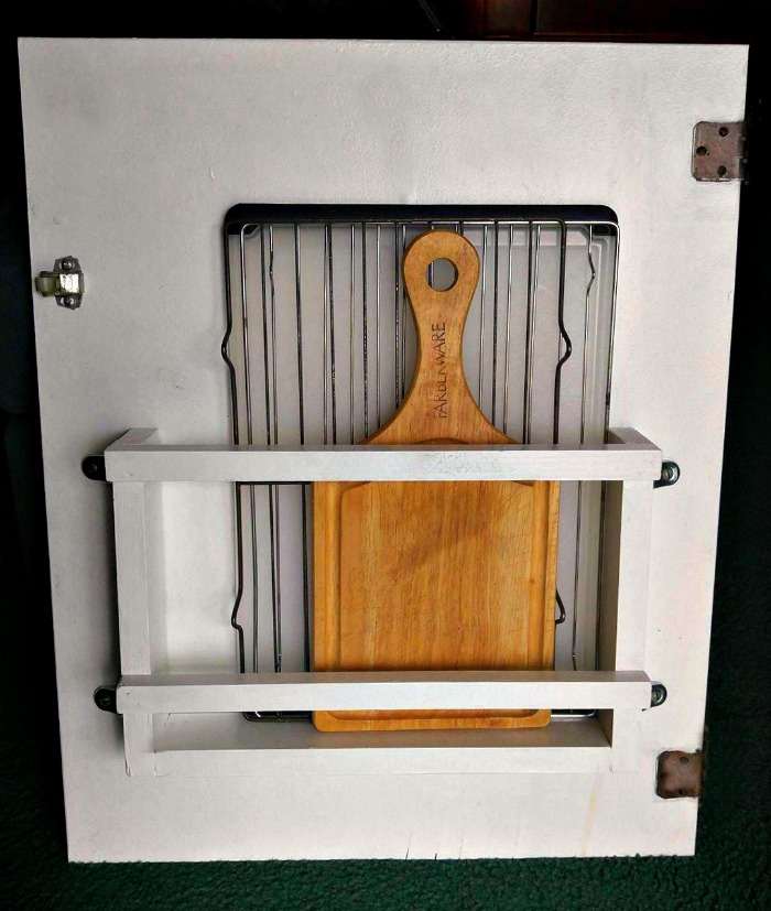 cutting boards and racks in a back of the door storage unit. Back of the door storage unit