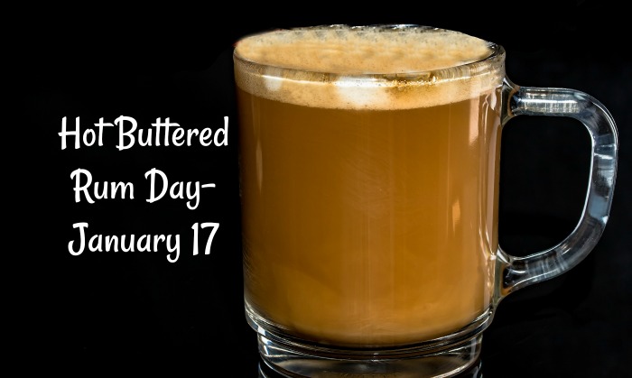 National Hot Buttered Rum Day text beside mug A clear mug of hot buttered rum against a black background with a text overlay to the left of it that says National Hot Buttered Rum Day, January 17.