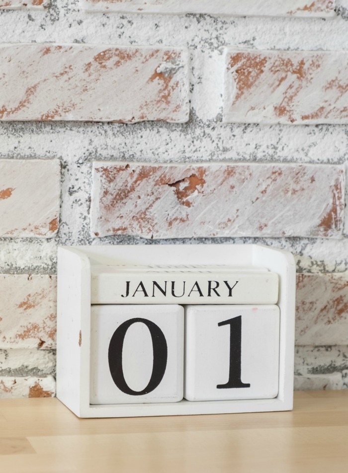 January 01 block calendar Brick wall with a block calendar dated January 01.